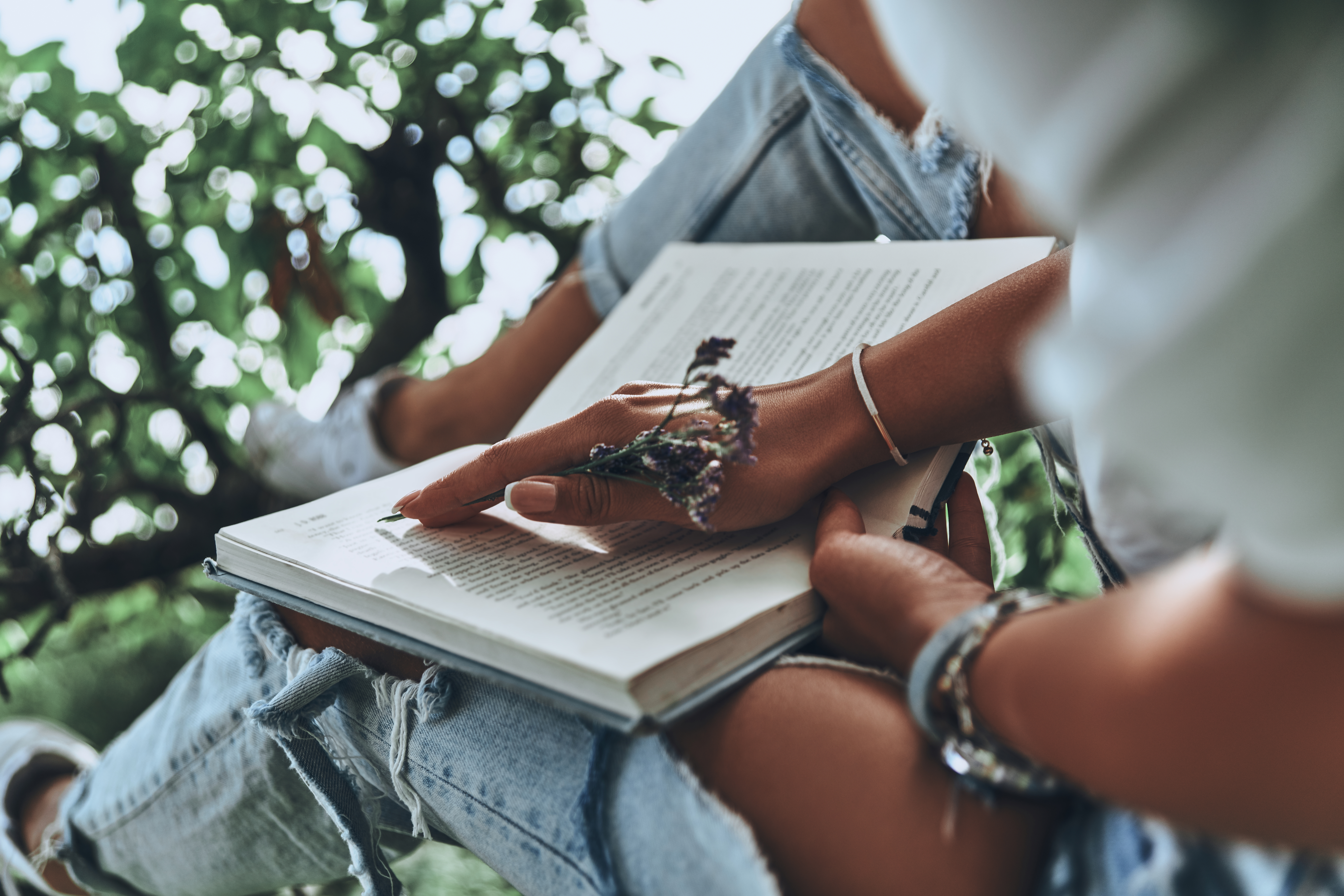 Her favorite book. Close-up of young woman holding an open book while spending time outdoors